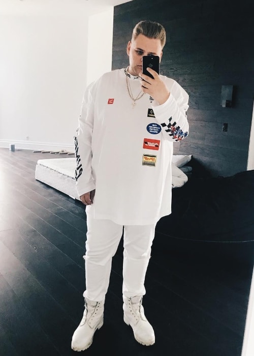 Nick Crompton as seen while taking a mirror selfie in a white outfit in November 2017